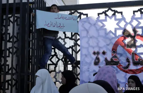 Palestinian women take part in a protest outside the Rafah crossing border, demanding the Egyptian authorities for the opening of the crossing, in Rafah in the southern Gaza Strip, December 25, 2014. The Egyptian authori...