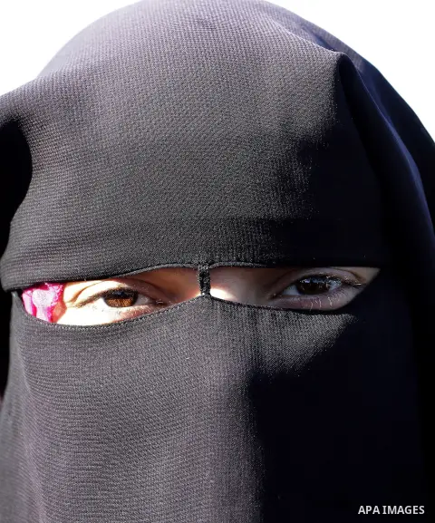 A Palestinian veiled woman looks on as she takes part in a protest outside the Rafah crossing border, demanding the Egyptian authorities for the opening of the crossing, in Rafah in the southern Gaza Strip, December 25,...