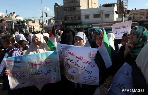 Palestinians take part in a protest calling for end the Israeli illegal blockade on Gaza Strip and against the slow rehabilitation of the strip after damage incurred during the recent Israeli offensive on Gaza Strip, in...