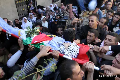 Mourners carry the body of 17-year-old Palestinian teenager Omam Dwekat, who was shot dead by Israeli troops the day before, during his funeral in the West Bank village of Baita, near of Nablus, on Dec. 30, 2014. Dwekat...
