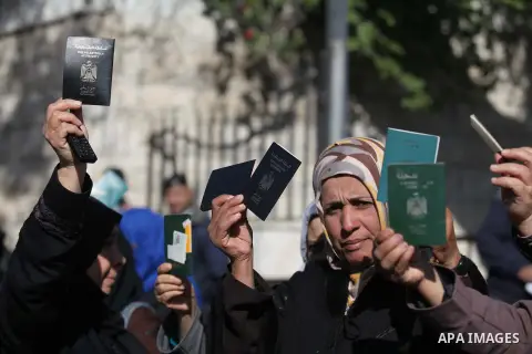 Palestinian women hold their passports during a protest demanding for the opening of Rafah crossing border in front of the headquarters of the Council of Ministers in Gaza city, on December 31, 2014. Photo by Ashraf Amra
