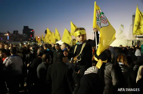 A Palestinian child watches a parade of Palestinian Fatah movement fighters during a rally marking the 50th anniversary of the founding of the Fatah movement, in the West Bank city of Ramallah December 31, 2014. Abbas si...