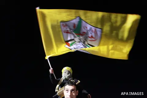 A Palestinian child watches a parade of Palestinian Fatah movement fighters during a rally marking the 50th anniversary of the founding of the Fatah movement, in the West Bank city of Ramallah December 31, 2014. Abbas si...