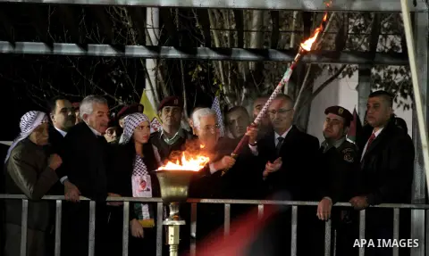 Palestinian President Mahmoud Abbas lights a torch during a rally marking the 50th anniversary of the founding of the Fatah movement, in the West Bank city of Ramallah December 31, 2014. Abbas signed on to 20 internation...