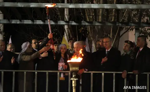 Palestinian President Mahmoud Abbas lights a torch during a rally marking the 50th anniversary of the founding of the Fatah movement, in the West Bank city of Ramallah December 31, 2014. Abbas signed on to 20 internation...