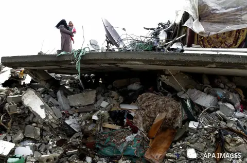 A Palestinian woman, stands on the rubbles of her house, which was destroyed by Israeli shelling during a 50- day-war last summer, on a stormy day in the east of Khan Younis in the southern Gaza Strip January 8, 2015. He...