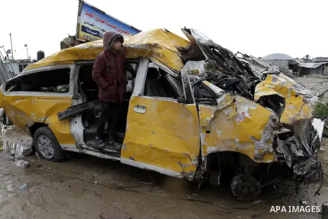 A Palestinian boy, who lives in a container as a temporary replacement for his family's house which was destroyed by what she said was Israeli shelling during a 50- day-war last summer, plays on the remains of a car on a...