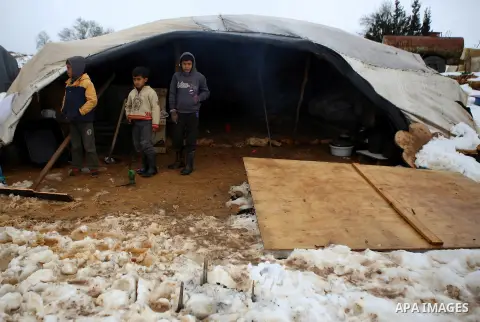 Palestinian Beduin children stand outside their tent after a snowfall near the West Bank city of Ramallah, January 8, 2015. A storm buffeted the Middle East with blizzards, rain and strong winds on Wednesday, keeping peo...