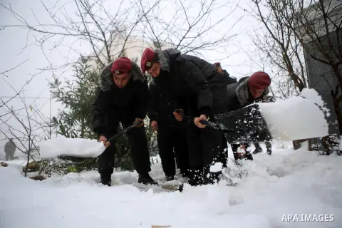 Palestinian security forces remove the snow from a street after a snowfall in the West Bank city of Ramallah, January 8, 2015. A storm buffeted the Middle East with blizzards, rain and strong winds on Wednesday, keeping...