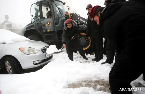 Palestinian security forces remove the snow from a street after a snowfall in the West Bank city of Ramallah, January 8, 2015. A storm buffeted the Middle East with blizzards, rain and strong winds on Wednesday, keeping...