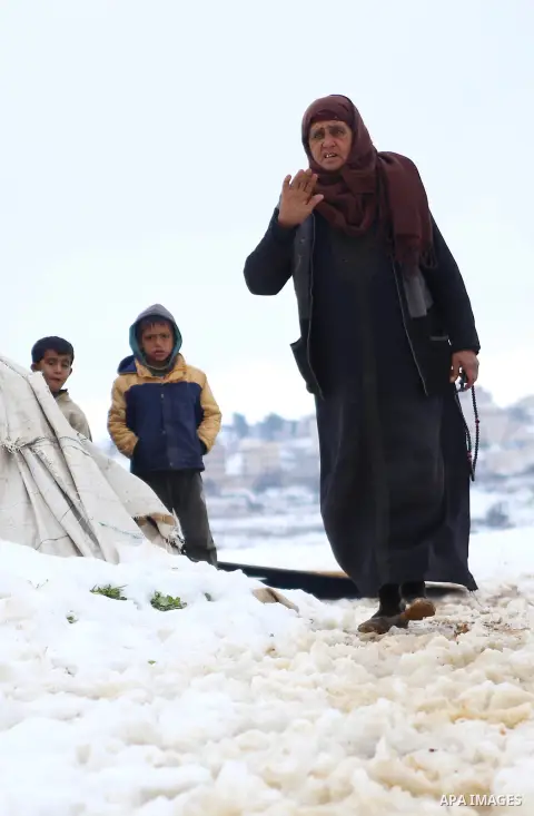 A Palestinian Beduin woman walks outside her tent after a snowfall near the West Bank city of Ramallah, January 8, 2015. A storm buffeted the Middle East with blizzards, rain and strong winds on Wednesday, keeping people...