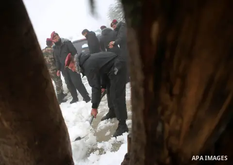 Palestinian security forces remove the snow from a street after a snowfall in the West Bank city of Ramallah, January 8, 2015. A storm buffeted the Middle East with blizzards, rain and strong winds on Wednesday, keeping...