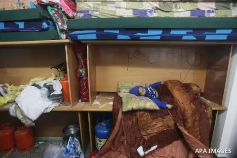 A Palestinian boy sleeps in a classroom at a United Nations (UN) run school sheltering Palestinians, whose houses were destroyed in the 50- day-war Israeli last summer, during a winter storm in Beit Hanoun in the norther...
