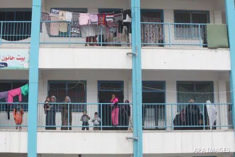 Palestinians stand outside classrooms at a United Nations (UN) run school sheltering Palestinians, whose houses were destroyed in the 50- day-war Israeli last summer, during a winter storm in Beit Hanoun in the northern...