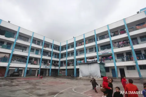 Palestinians children play at a United Nations (UN) run school sheltering Palestinians, whose houses were destroyed in the 50- day-war Israeli last summer, during a winter storm in Beit Hanoun in the northern Gaza Strip...