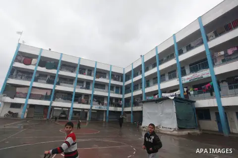 Palestinians children play at a United Nations (UN) run school sheltering Palestinians, whose houses were destroyed in the 50- day-war Israeli last summer, during a winter storm in Beit Hanoun in the northern Gaza Strip...