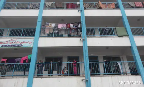 Palestinians stand outside classrooms at a United Nations (UN) run school sheltering Palestinians, whose houses were destroyed in the 50- day-war Israeli last summer, during a winter storm in Beit Hanoun in the northern...