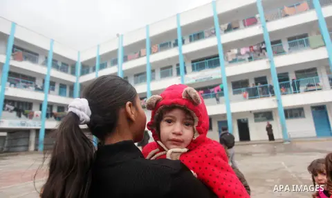 Palestinians children play at a United Nations (UN) run school sheltering Palestinians, whose houses were destroyed in the 50- day-war Israeli last summer, during a winter storm in Beit Hanoun in the northern Gaza Strip...