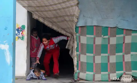 Palestinians children play at a United Nations (UN) run school sheltering Palestinians, whose houses were destroyed in the 50- day-war Israeli last summer, during a winter storm in Beit Hanoun in the northern Gaza Strip...
