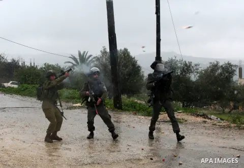 Israeli security forces fire tear gas towards Palestinian protesters during clashes following a demonstration against the expropriation of Palestinian land by Israel in the West Bank village of Kfar Qaddum, near Nablus,...