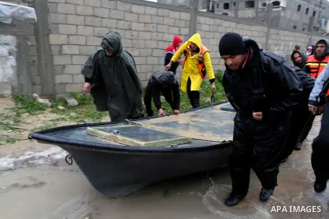 Members of Palestinian Civil Defence prepare to evacuate people following heavy rain that flooded their houses in Rafah in the southern Gaza Strip January 9, 2015. Heavy rains and near-freezing temperatures in the approa...