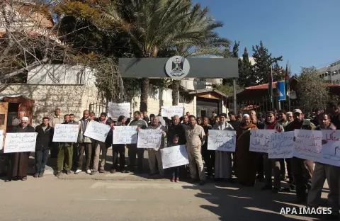 Palestinians take part in a protest organized by employees of former Palestinian government demanding their salaries to be paid, in front of the headquarters of the Council of Ministers in Gaza city on January 20, 2015....