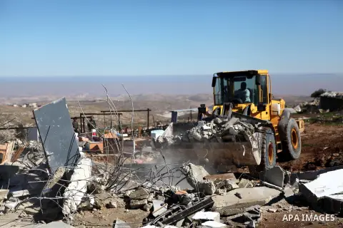 An Israeli bulldozers demolishes two houses belongings to Palestinians in the south of the West Bank city of Hebron January 20, 2015. The owners of the house said they were informed by the Israeli army that the demolitio...