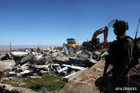 An Israeli border policeman stands guard after two houses belongings to Palestinians were demolished by the Israeli army south of the West Bank city of Hebron January 20, 2015. The owners of the house said they were info...