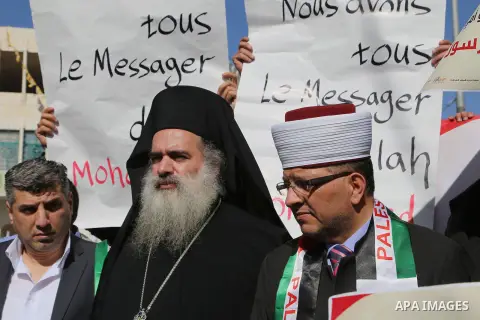 Bishop Atallah Hanna with Palestinian men take part in a protest against satirical French weekly magazine Charlie Hebdo's cartoons of the Prophet Mohammad, in the West bank city of Hebron January 22, 2015. Charlie Hebdo...