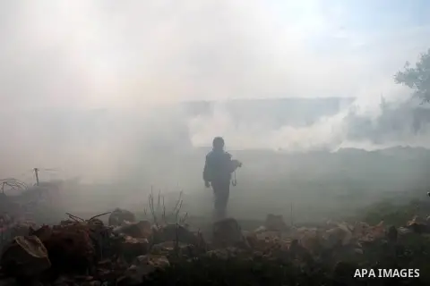 A Palestinian photojournalist stands amid of tear gas clouds during clashes between Palestinian protesters and Israeli security forces after a march to protest against Israeli settlements in the West Bank village of Bili...
