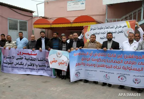 Palestinian doctors and workers of the health sector hold placards during a protest calling the government for pay their salaries, at Nasser hospital in Khan Younis in the southern Gaza Strip on January 26, 2015. Photo b...