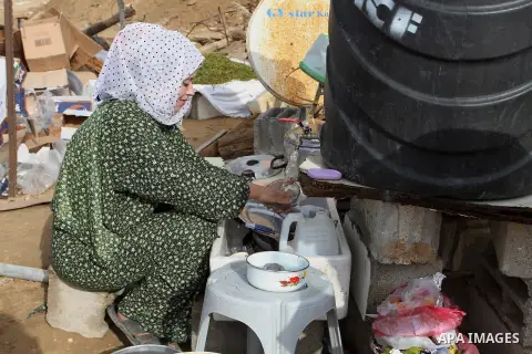 A Palestinian woman, whose house was destroyed by what witnesses said was Israel shelling during a 50-day conflict last summer, works outside her tent east of Khan Younis in the southern Gaza Strip January 27, 2015. The...