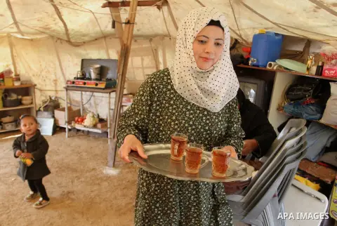 A Palestinian woman prepares tea at a tent near the ruins of her house which witnesses said were destroyed by Israel shelling during a 50-day conflict last summer, east of Khan Younis in the southern Gaza Strip January 2...