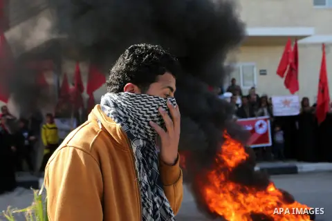 Palestinian protesters burn tires during a protest organised by the Democratic Front for the Liberation of Palestine against United Nations, after the UN announced a lack of funds to rebuild the Palestinian territory, ou...