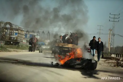 Palestinian protesters burn tires during a protest against the Israeli siege on Gaza strip near the Nahal Oz crossing east of Gaza City on February 1, 2015. Photo by Ashraf Amra