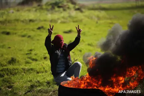 A Palestinian protester burns tires during a protest against the Israeli siege on Gaza strip near the Nahal Oz crossing east of Gaza City on February 1, 2015. Photo by Ashraf Amra
