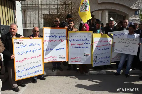 Palestinians hold banners during a protest to show solidarity with the Jordanian pilot Muath al-Kasaesbeh, who was died by the hardline group in front of the Jordanian Embassy in the West Bank city of Ramallah, on Februa...