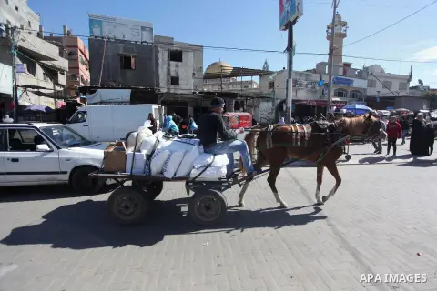 Palestinians receive aid during a protest in Gaza city on February 5, 2015 after the UN announced a lack of funds to rebuild the Palestinian territory. Around 200 people demonstrated outside headquarters burning tyres an...