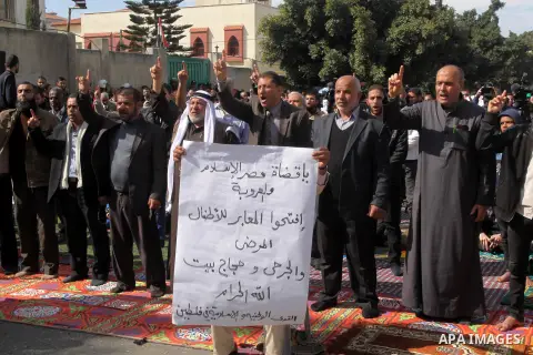Palestinian Hamas supporters attend Friday prayers outside the Egyptian embassy in a protest to condemn the decision of an Egyptian court to ban the armed wing of Palestinian Islamist movement, in Gaza city on February 6...