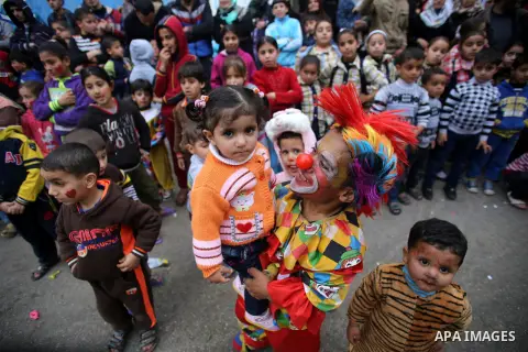 A clown plays with Palestinian children during a street game organised by volunteers of the Friday of Joy Initiative, in al-Shati refugee camp, in Gaza city, February 6, 2015. Ten Palestinian volunteers organise street g...