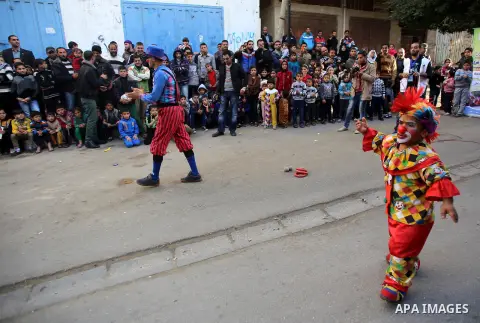 Clowns perform in front of Palestinian children during a street game organised by volunteers of the Friday of Joy Initiative, in al-Shati refugee camp, in Gaza city, February 6, 2015. Ten Palestinian volunteers organise...