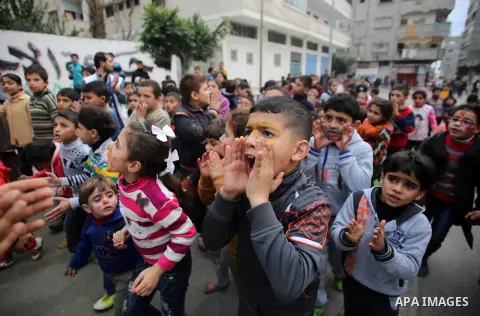 Palestinian children attend a street game organised by volunteers of the Friday of Joy Initiative, in al-Shati refugee camp, in Gaza city, February 6, 2015. Ten Palestinian volunteers organise street games, painting and...