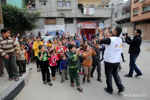 A volunteer of the Friday of Joy Initiative, plays with children in the street in al-Shati refugee camp, in Gaza city, February 6, 2015. Ten Palestinian volunteers organise street games, painting and drama, every Friday...