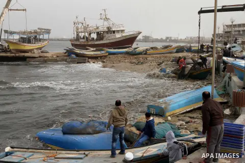Palestinian fishermen pull their boats from seaport during a sandstorm on February 11, 2015. Photo by Mohammed Asad