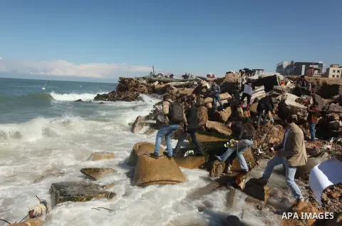 Palestinians throw flowers into the sea, in remembrance of the Chapel Hill shooting victims, in Gaza City, February 14, 2015. Three young Muslims were gunned down in Chapel Hill, North Carolina, this week. Newlywed Deah...
