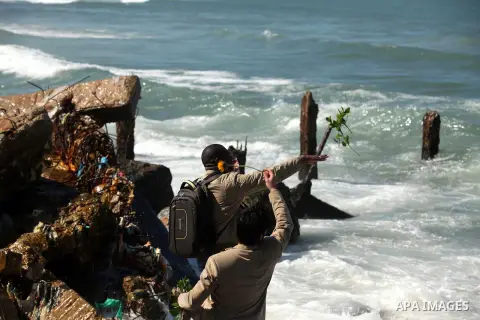 Palestinians throw flowers into the sea, in remembrance of the Chapel Hill shooting victims, in Gaza City, February 14, 2015. Three young Muslims were gunned down in Chapel Hill, North Carolina, this week. Newlywed Deah...