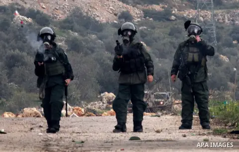 Israeli border policemen fire tear gas at Palestinian protesters during clashes following a protest against closure of the village road, in the West Bank village of Azzun near Qalqilya February 14, 2015. Photo by Nedal E...