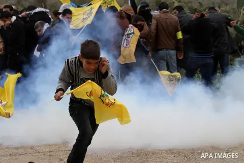Palestinian Protesters run away from tear gas fired by Israeli border policemen during clashes following a protest against closure of the village road, in the West Bank village of Azzun near Qalqilya February 14, 2015. P...