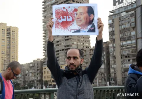 Members of the April 6 movement hold placards during a demonstration of October bridge in Cairo, Egypt on February 14, 2015. Photo by Amr Sayed