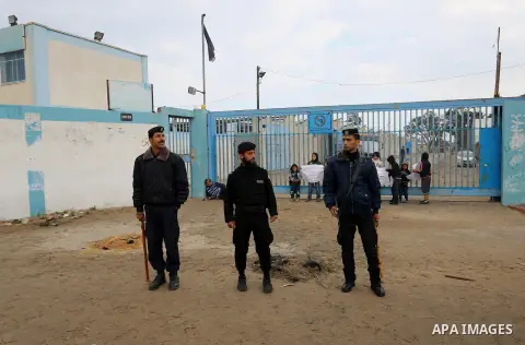 Palestinian policemen loyal to Hamas stand guard near burning tyres during a protest by Palestinians calling for reconstruction of their houses that witnesses said were destroyed by Israeli shelling during a 50-day war l...